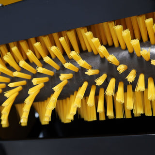 Close-up of a brush with yellow bristles on a black background
