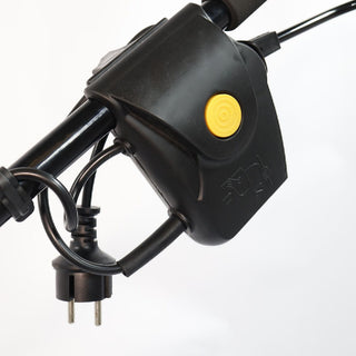 Black electrical plug with yellow button on a white background