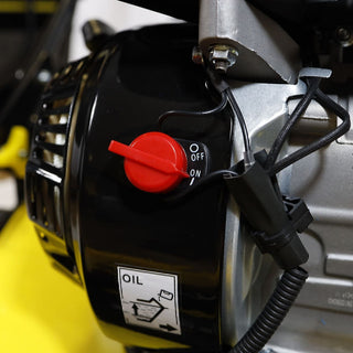 Close-up of a chainsaw with a red ignition switch and oil cap on a yellow background.