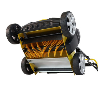 A yellow and black Roll&Comb roller with wide wheels and a row of orange cleaning bristles underneath, shown from an elevated angle on a white background.